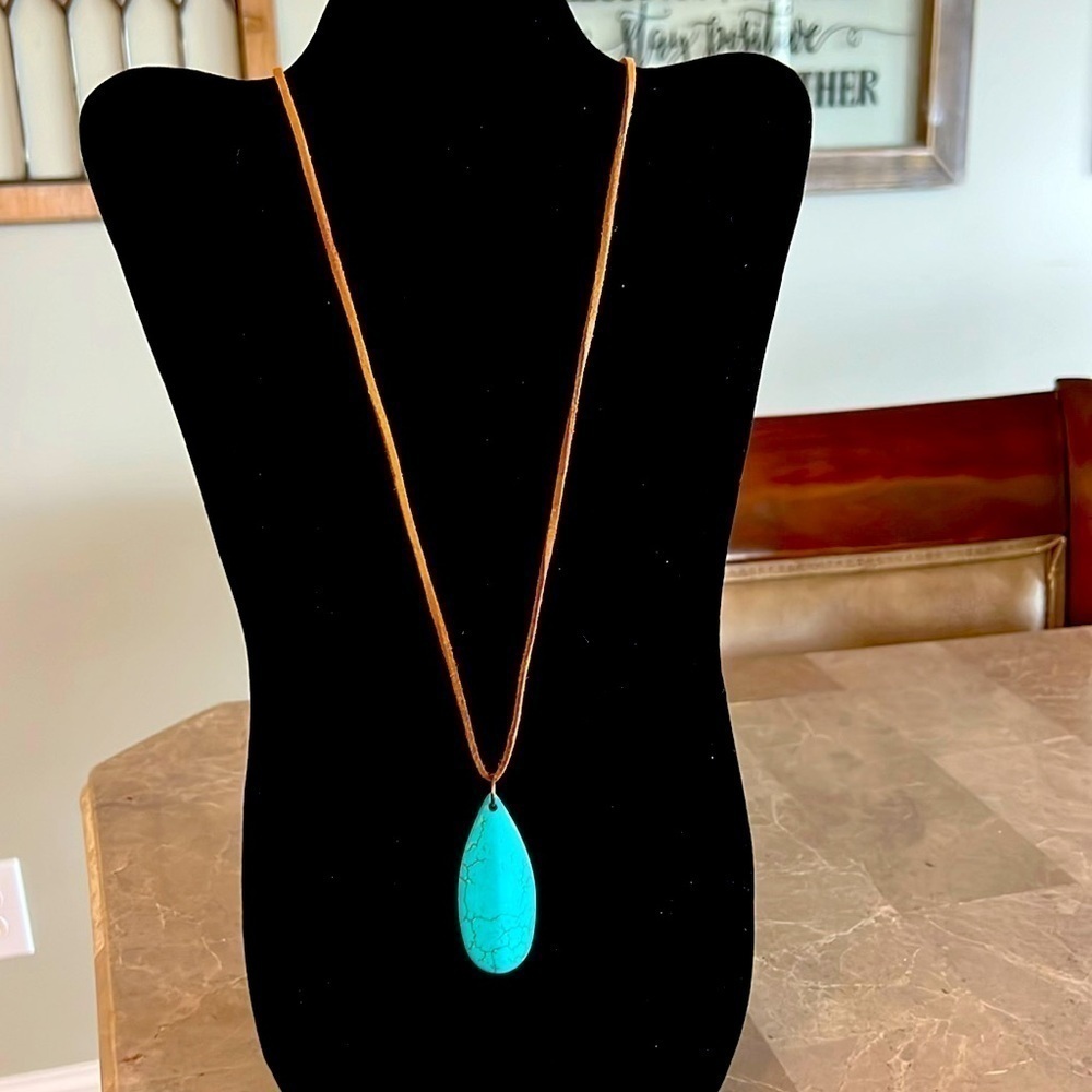 Turquoise pendant necklace with leather cord.